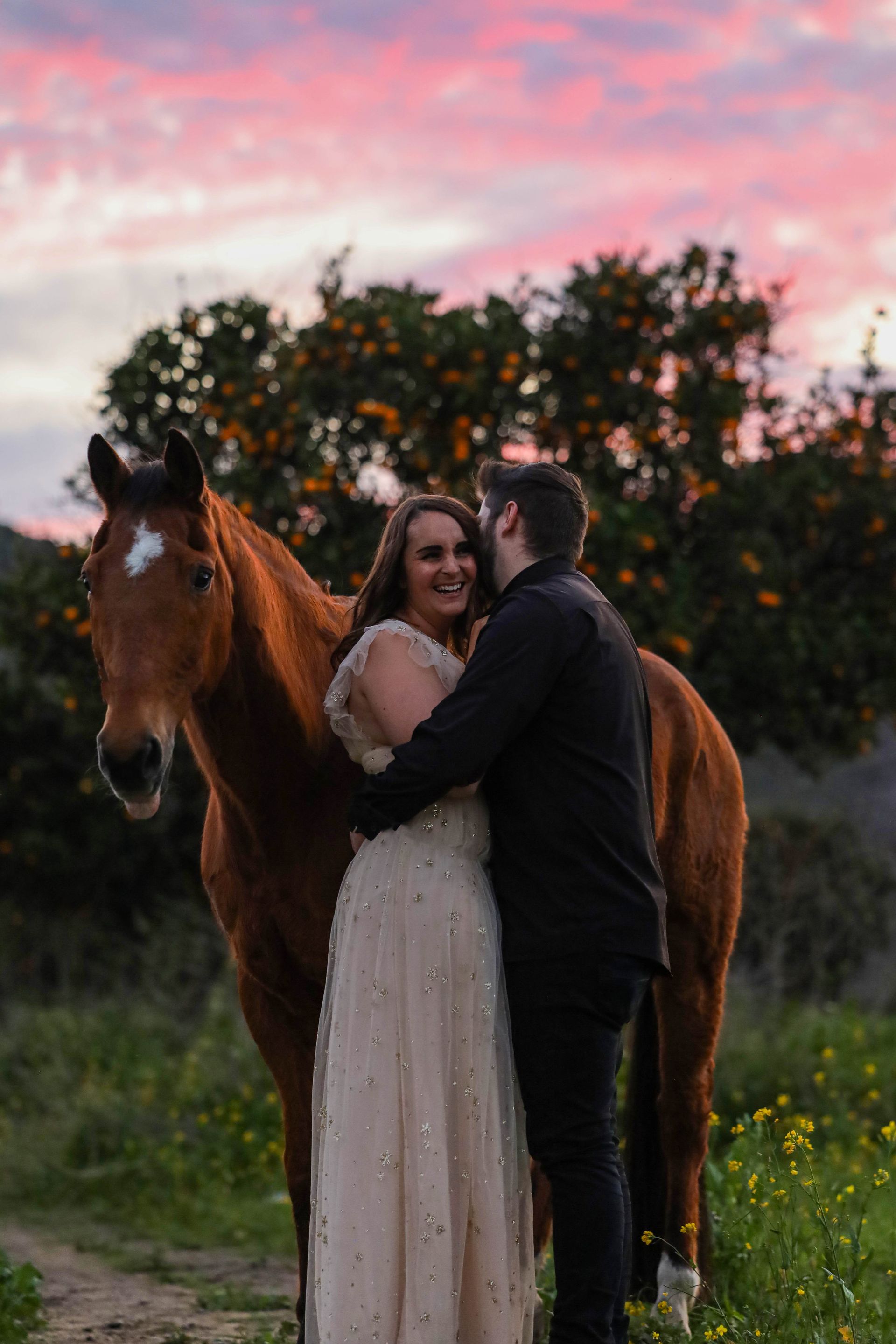 couple laughing with horse 