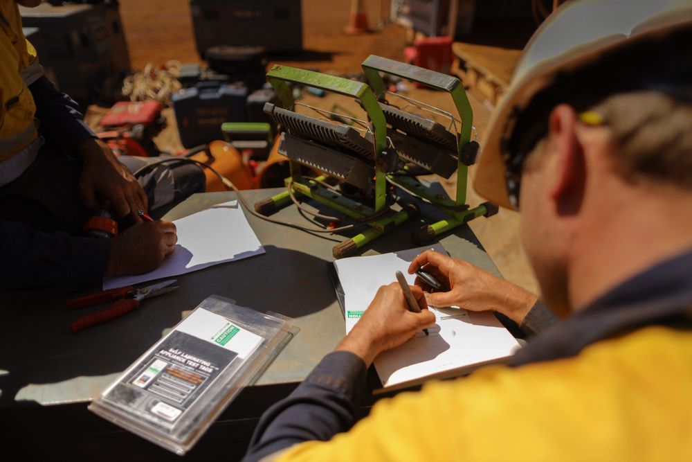 A Man in a Hard Hat is Writing on a Piece of Paper — Barling Constructions in Casino, NSW