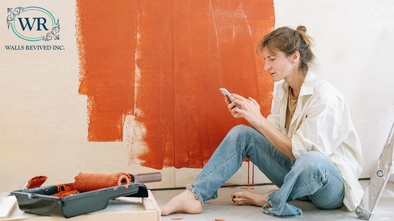 Lady looking at her phone, thinking about when and how to paint her house during a renovation