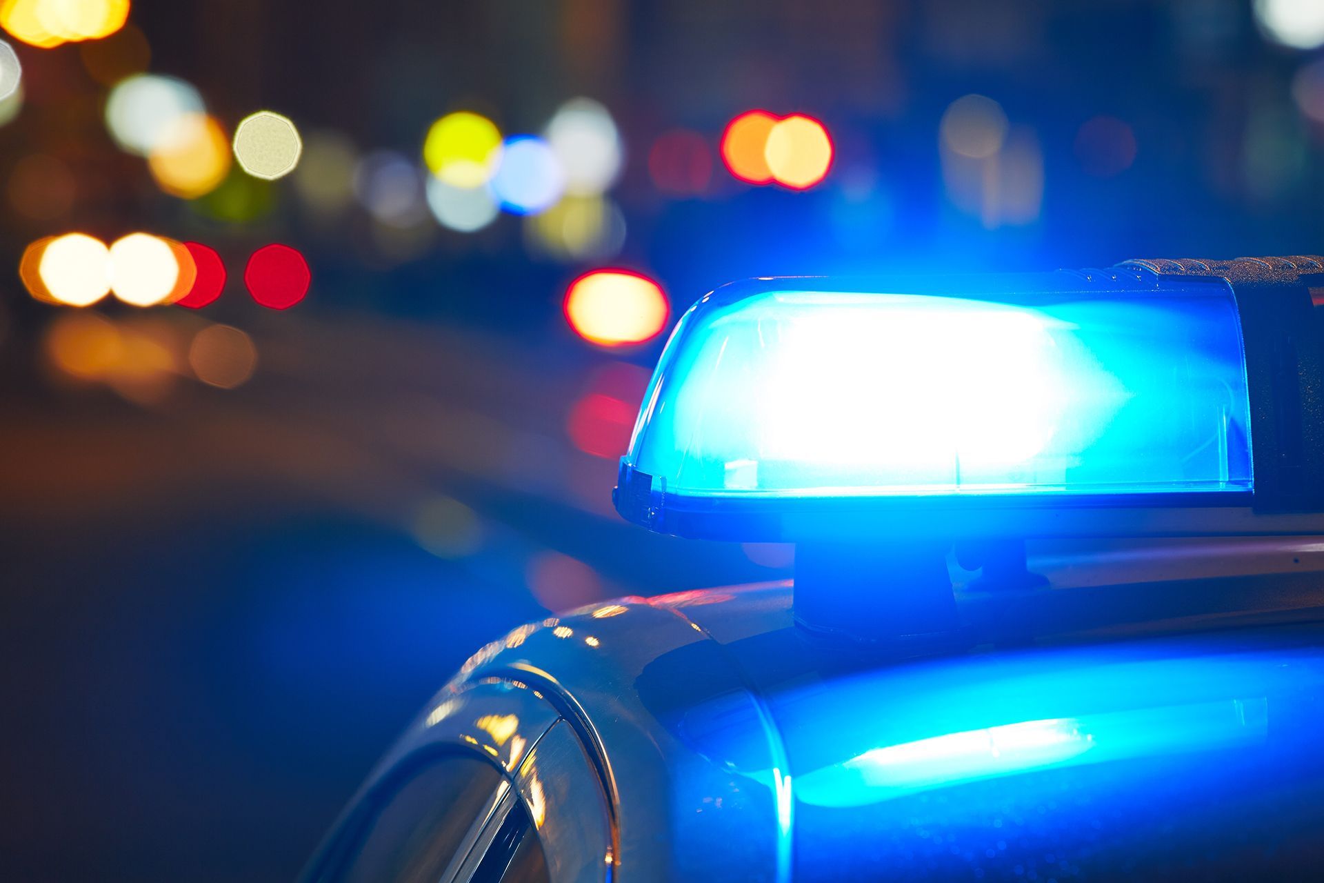 A close up of a patrol car with a blue light on top of it.