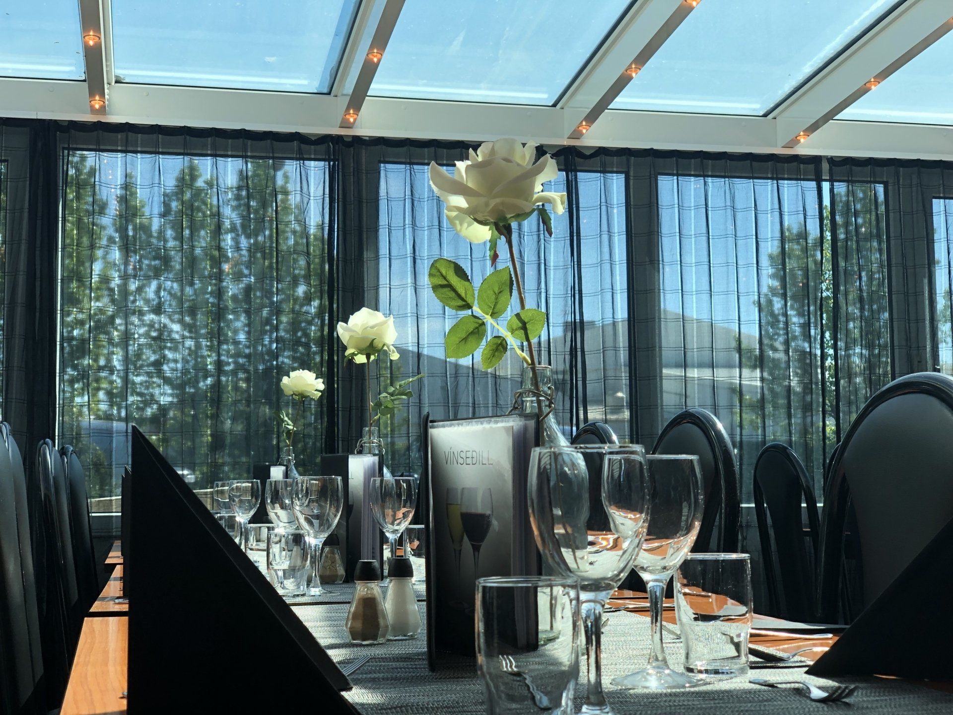 A restaurant with a glass roof and a table set for a meal.