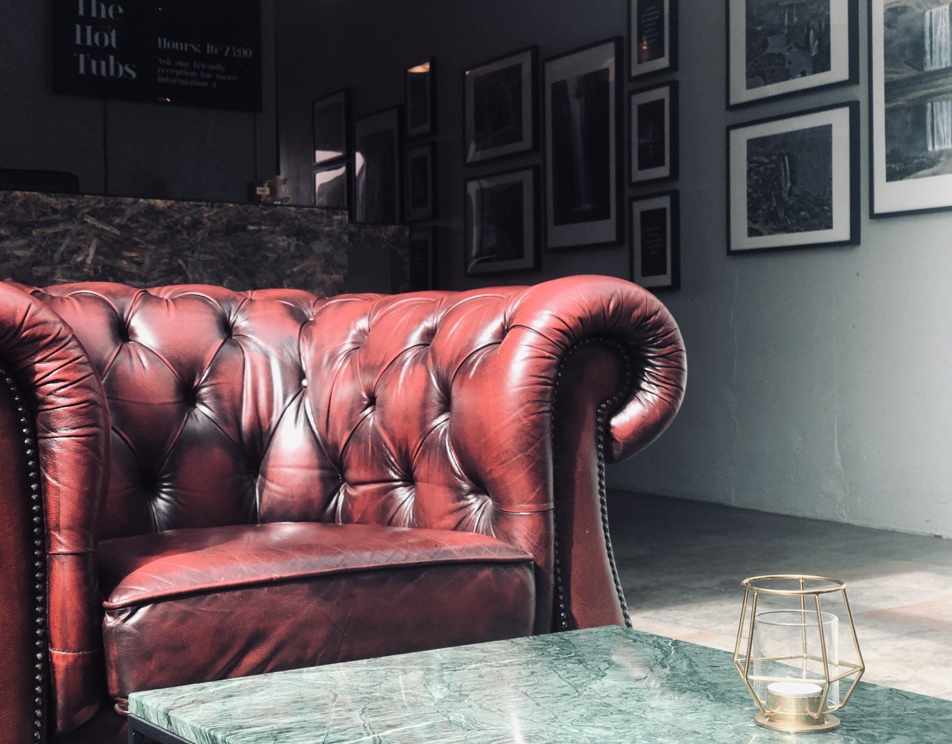 A red leather couch is sitting on a green table