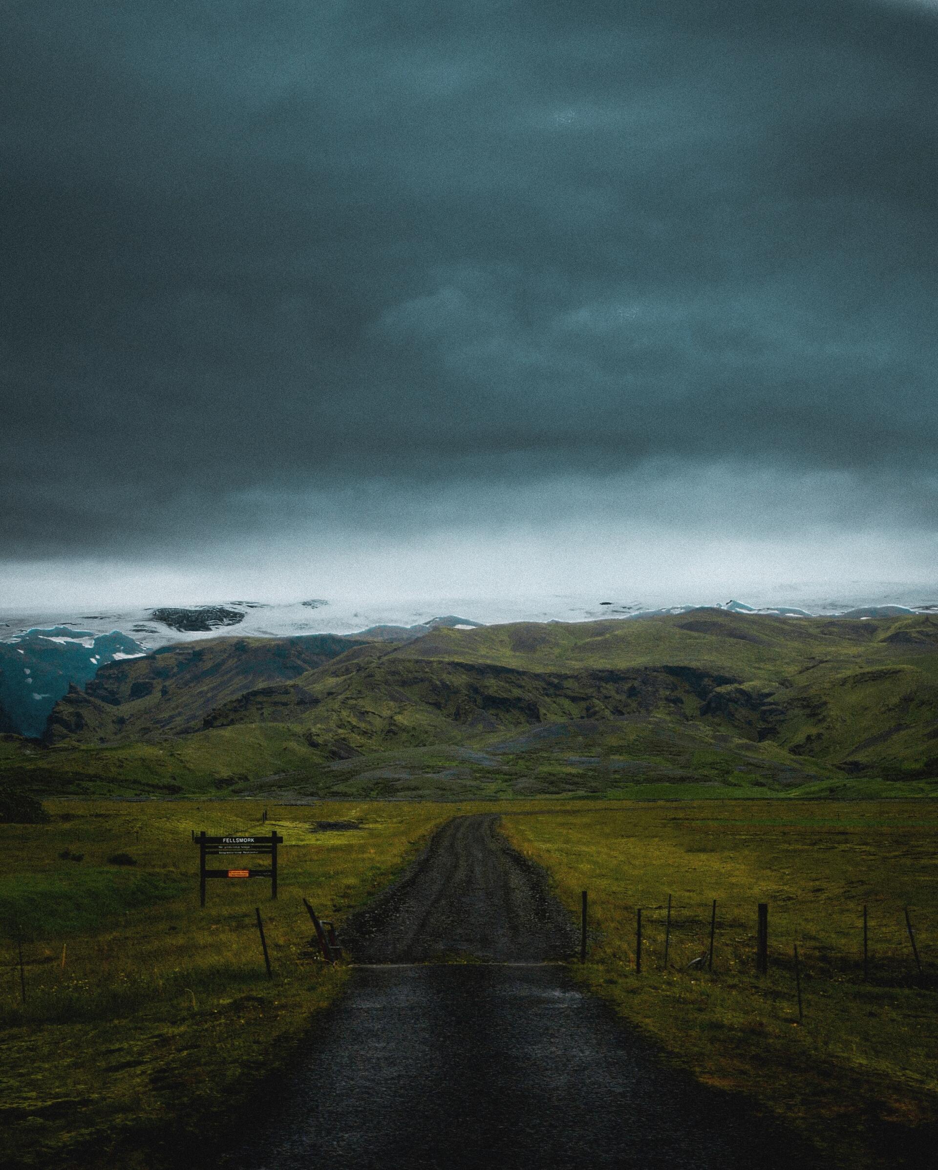 A road going through a grassy field towards Iceland highlands