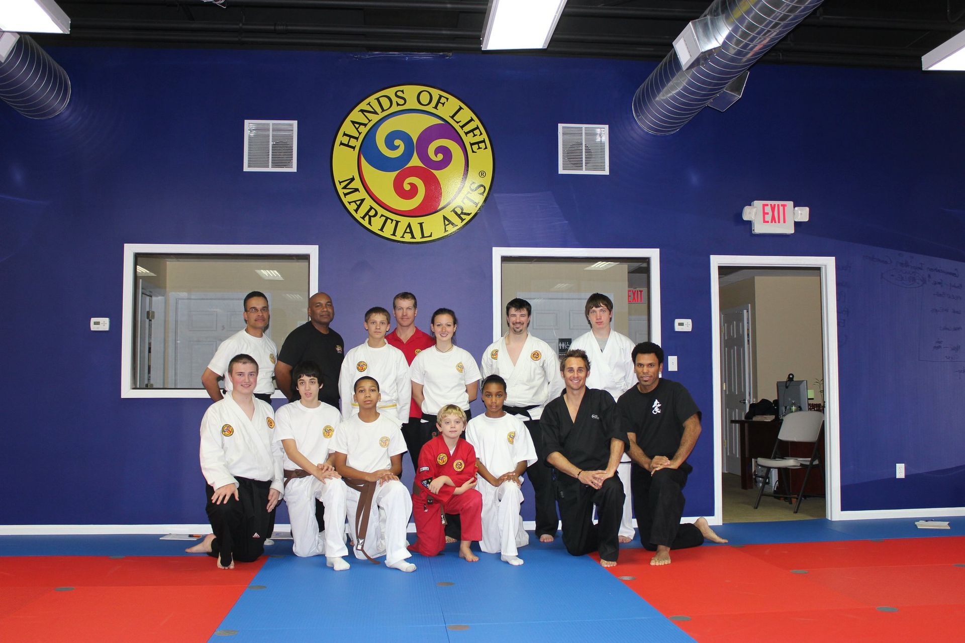 A group of people posing for a picture in front of a sign that says hands on life martial arts