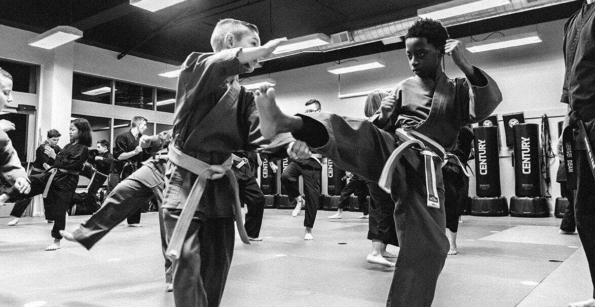 A group of people are practicing martial arts in a gym.