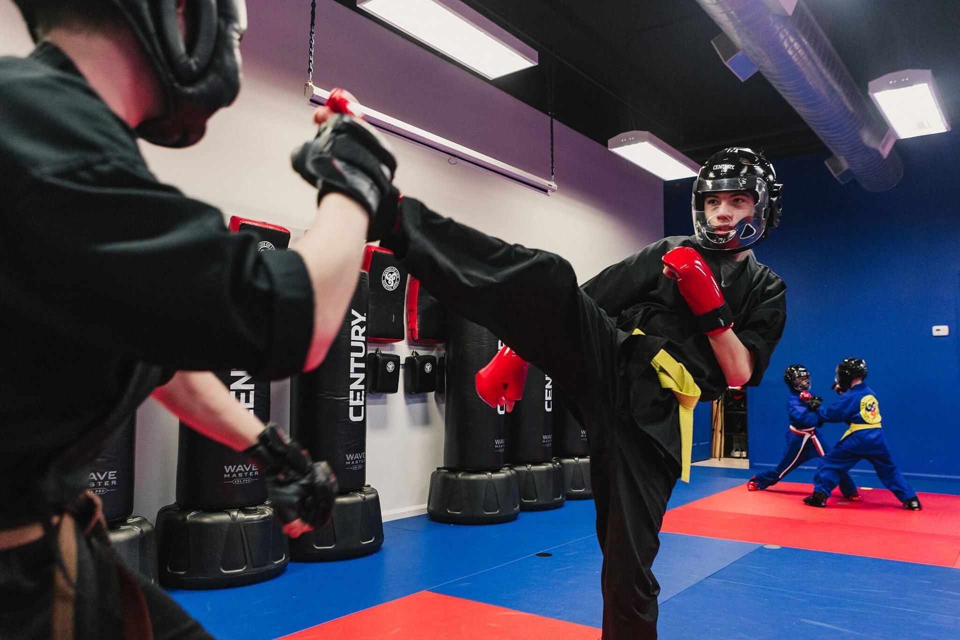 Two men are practicing martial arts in a gym.
