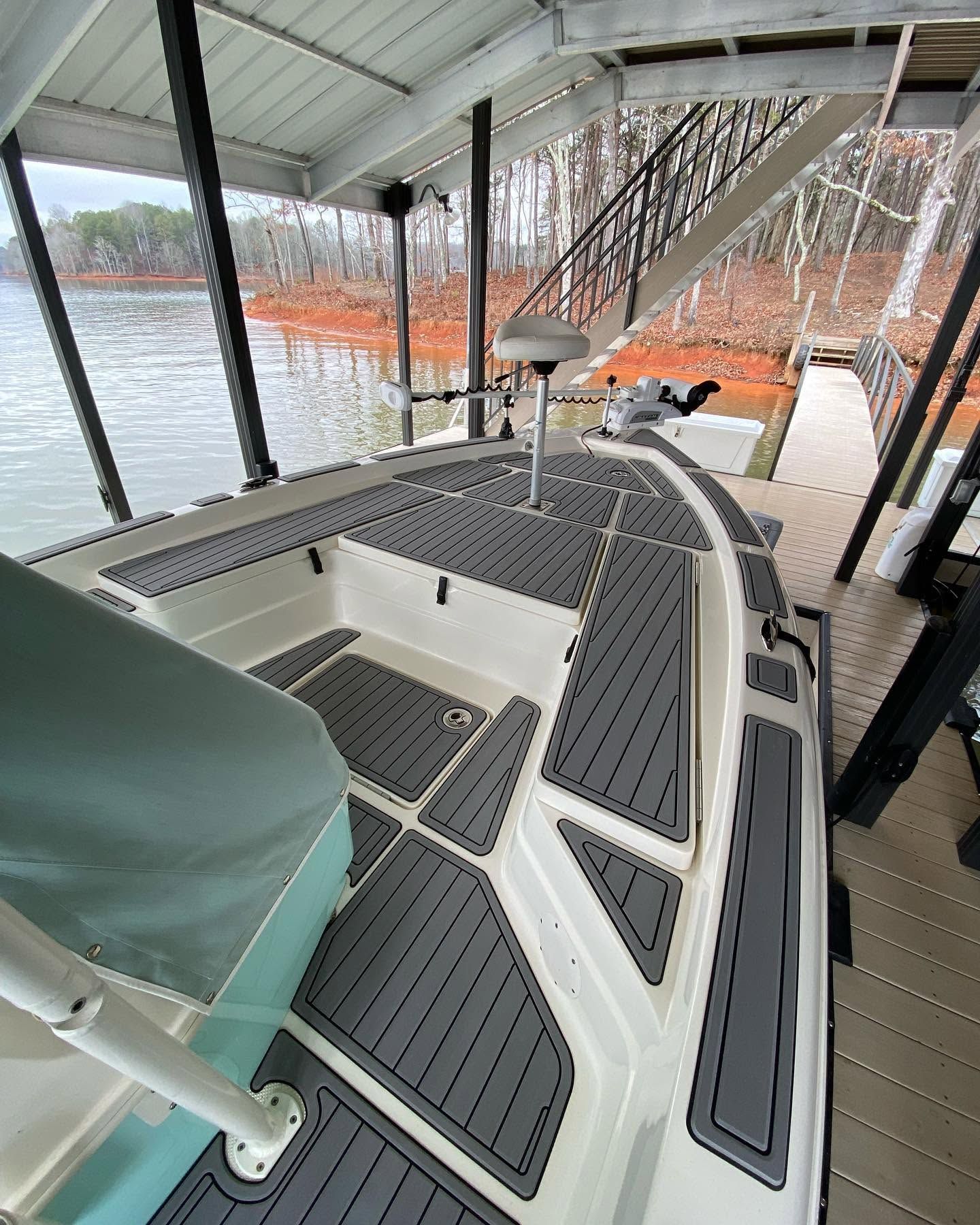 Covered dock with a small boat moored beside the water, seen through clear plastic curtains.