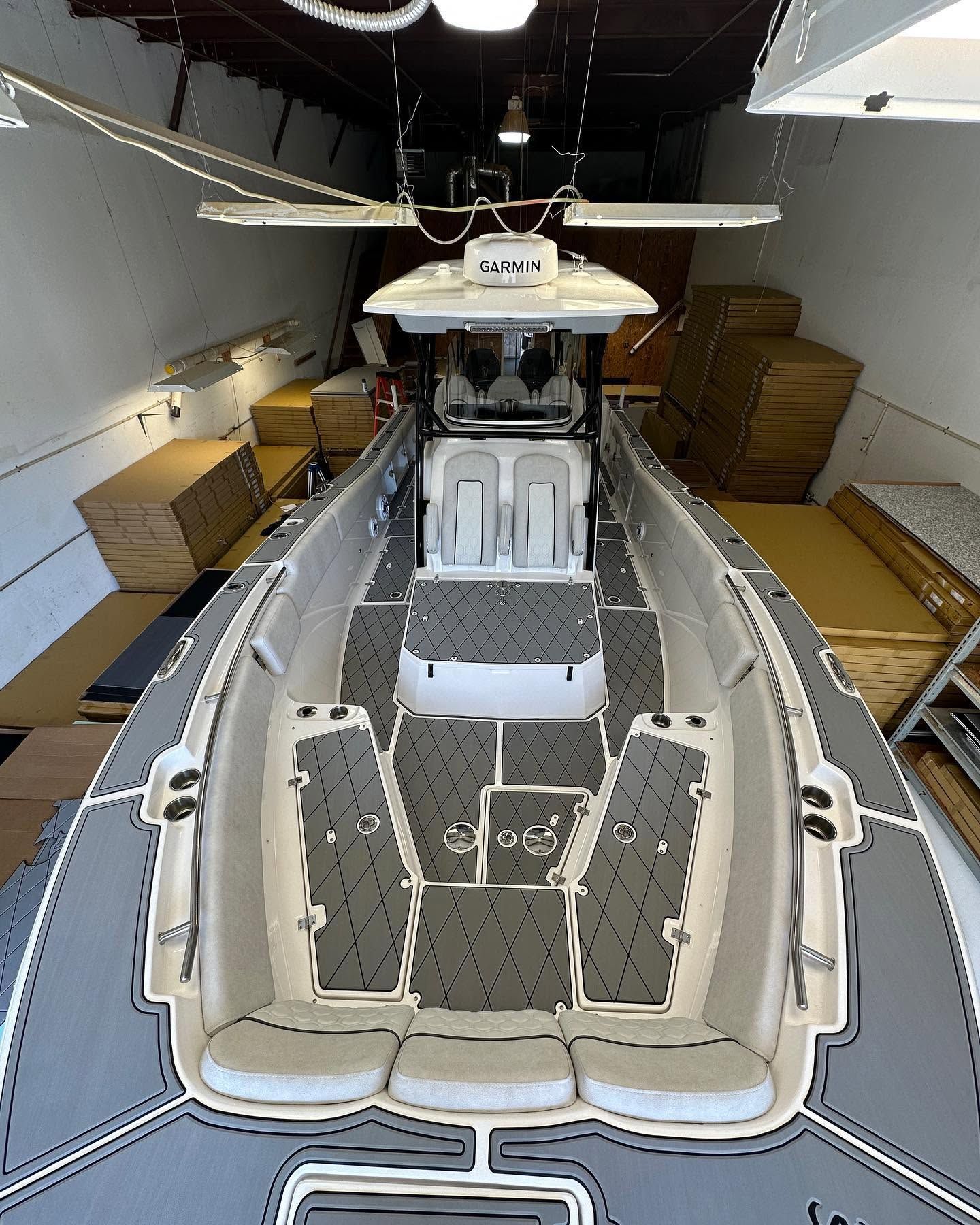 Interior of a white boat cabin with open center seating, viewed from above, in a storage garage