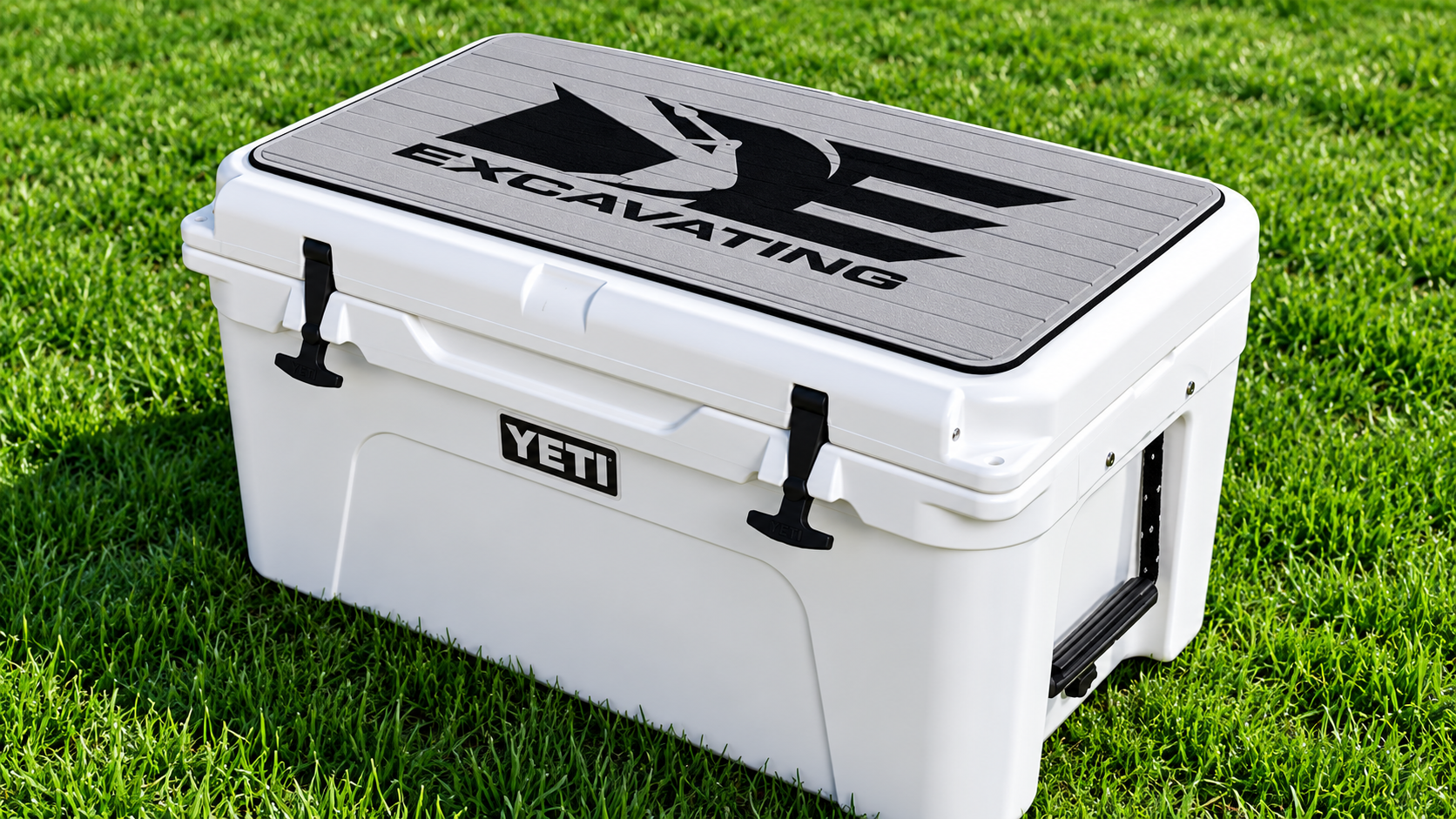 White YETI cooler with black lid logo sitting on green grass