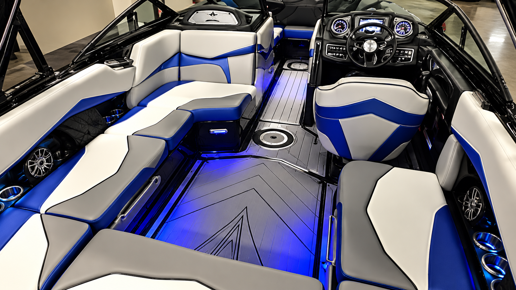 Interior of a modern boat with white and blue seating and LED floor lighting