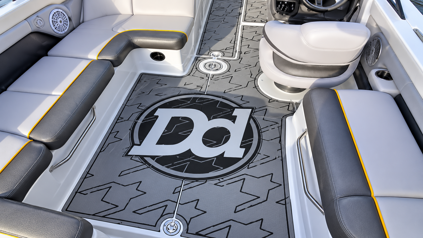 Luxury boat deck with gray seating, white flooring, and a black “Pd” logo mat in the center