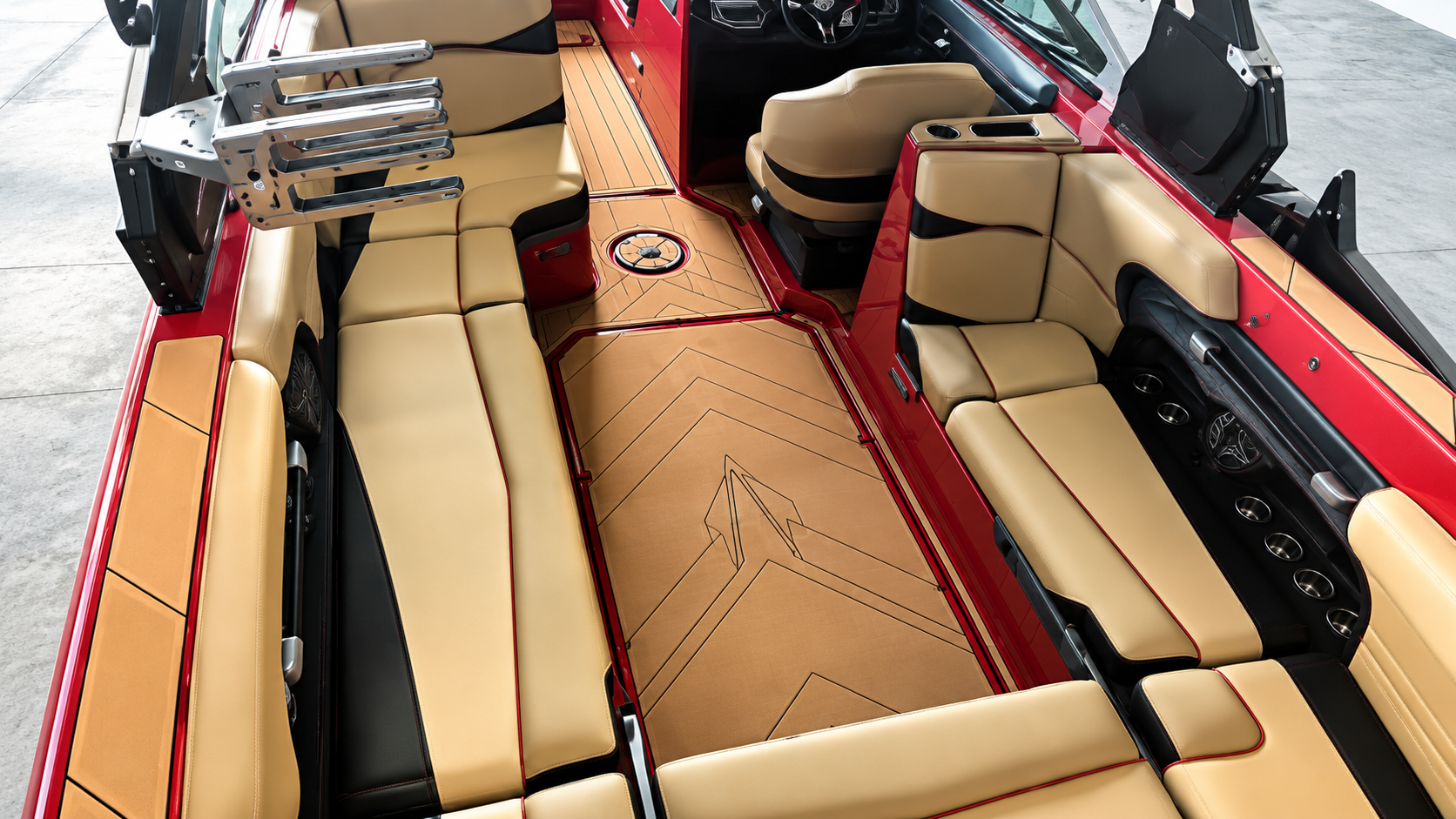 Tan and black boat interior with cushioned seating and a central floor panel, viewed from above.