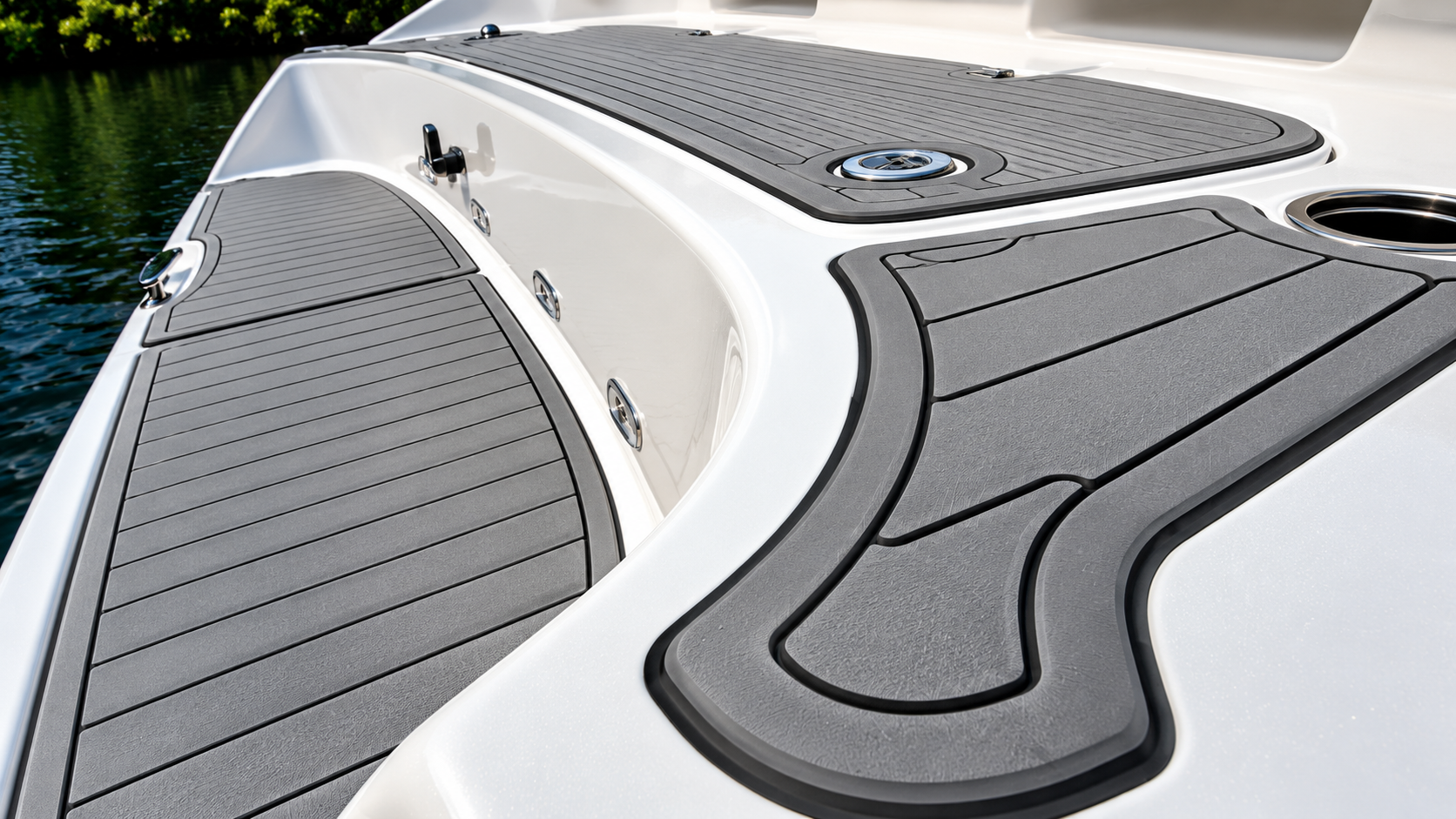 Close-up of a boat deck with gray non-slip flooring and white curved seating area
