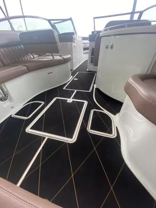 Narrow boat cabin with curved bench seats, white cabinetry, and black carpeted steps and floor mats