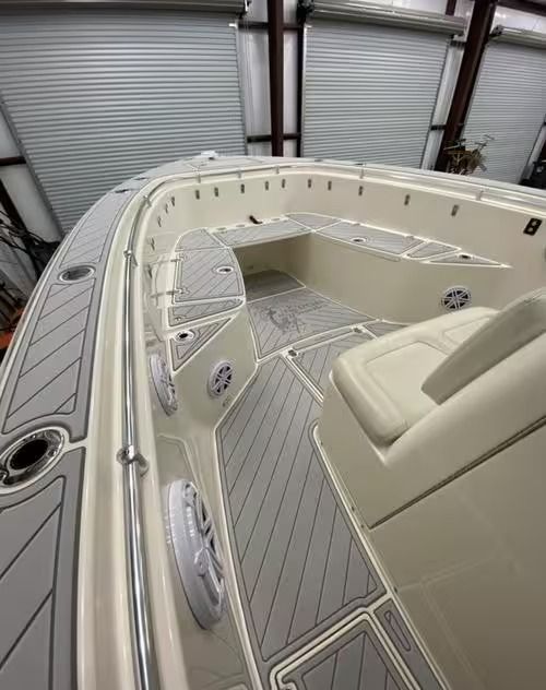 Inside a boat cabin: cream seating and gray deck flooring in a dockside storage bay