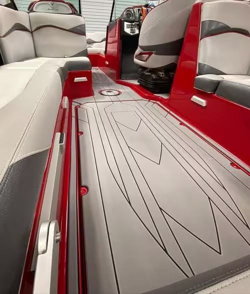 Red boat interior with gray cushioned seating and a geometric floor design.