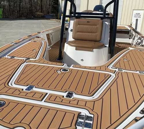 Boat deck with tan non-slip flooring and a cushioned captain’s chair at the helm