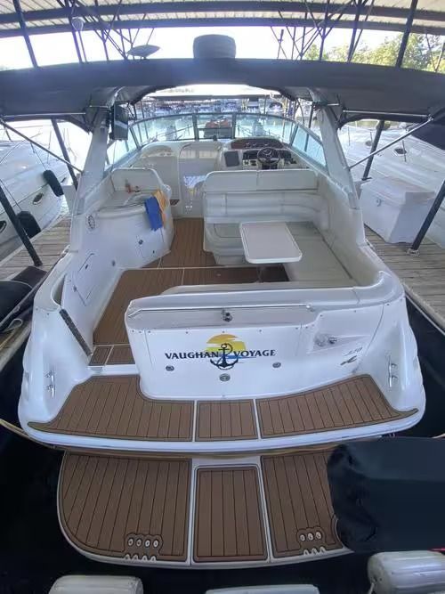 Luxury yacht interior with white seating, teak deck, and canopy at a marina dock