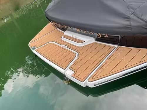 Boat stern with teak deck trim floating on green water