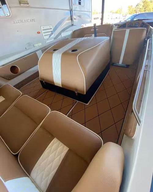 Tan cabin with cushioned seating and a central table on a boat interior