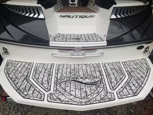 White car trunk with decorative black-and-white patterned mat and chrome trim under the open hatch