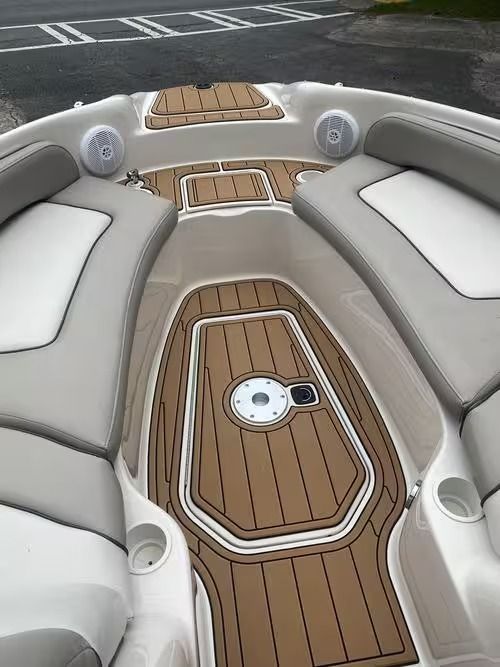 White and tan boat cockpit with cushioned seating and teak-style deck panels
