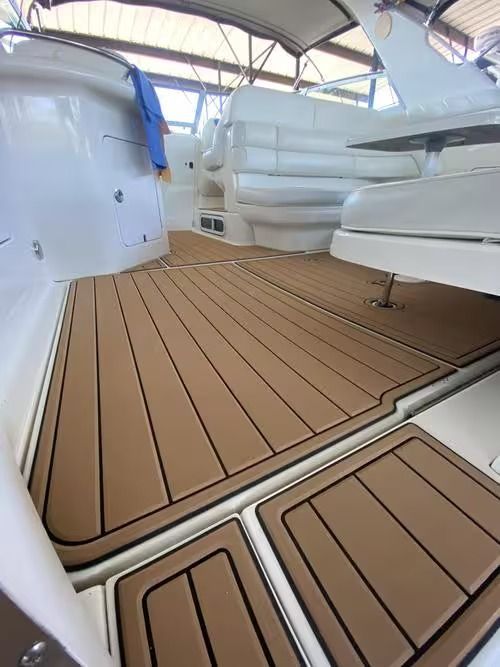 Boat deck with tan teak-style flooring, white seating, and a canopy overhead