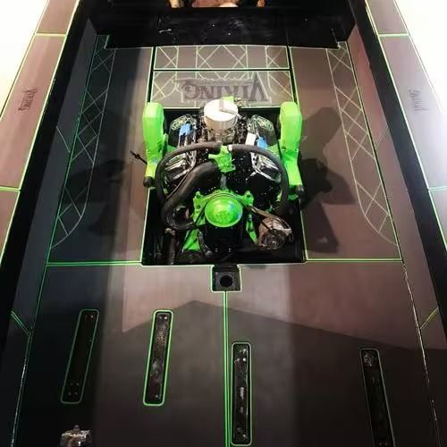 Small green-and-black robot in a box-lined test arena, viewed from above