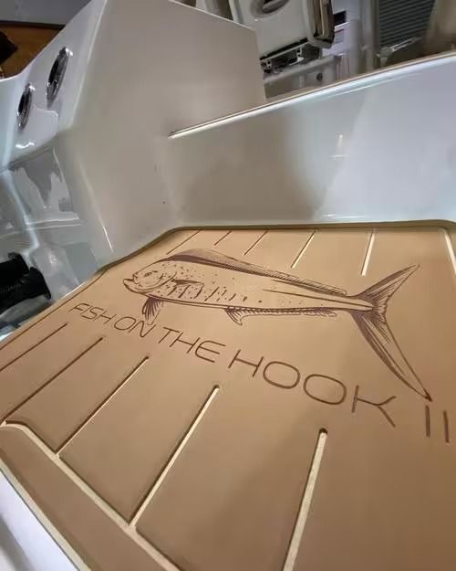 Tan leather-bound menu embossed with a fish and “HOOK,” on a restaurant table.