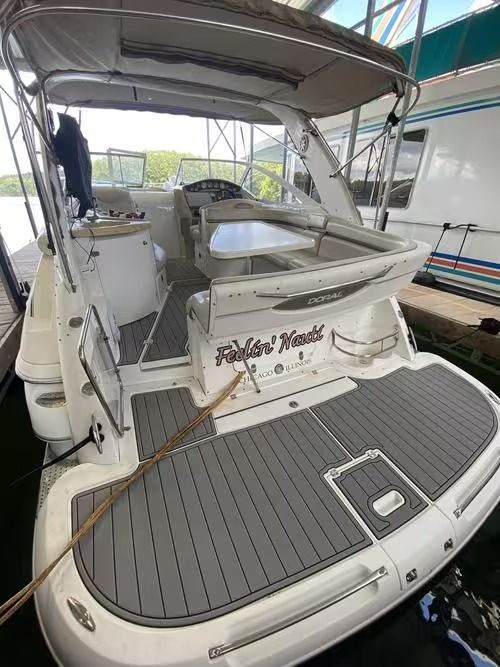 White motor yacht stern with gray deck in a covered marina berth