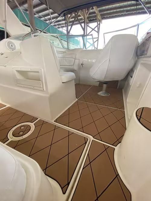 White boat cabin with seats and brown tiled floor under a covered deck