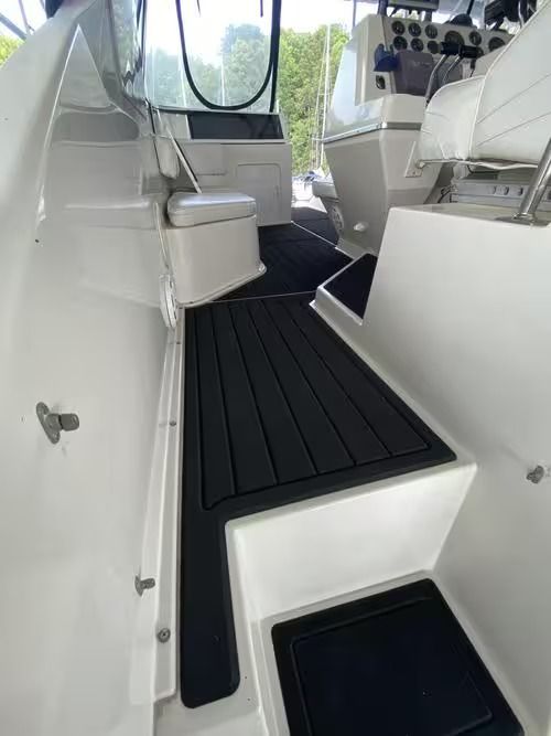 White boat cabin interior with black nonslip flooring and seating along the sides