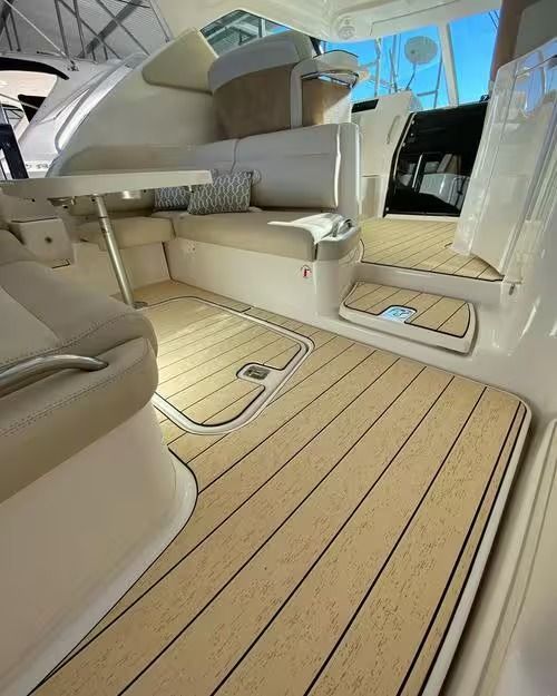 Luxury boat cabin with cream seating and light wood flooring, seen from the entryway.