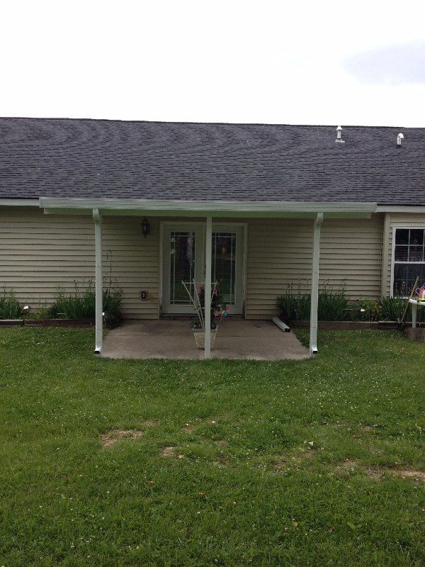 The back of a house with a covered patio and a sliding glass door.