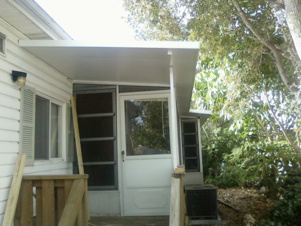 A white house with a screen door and a porch