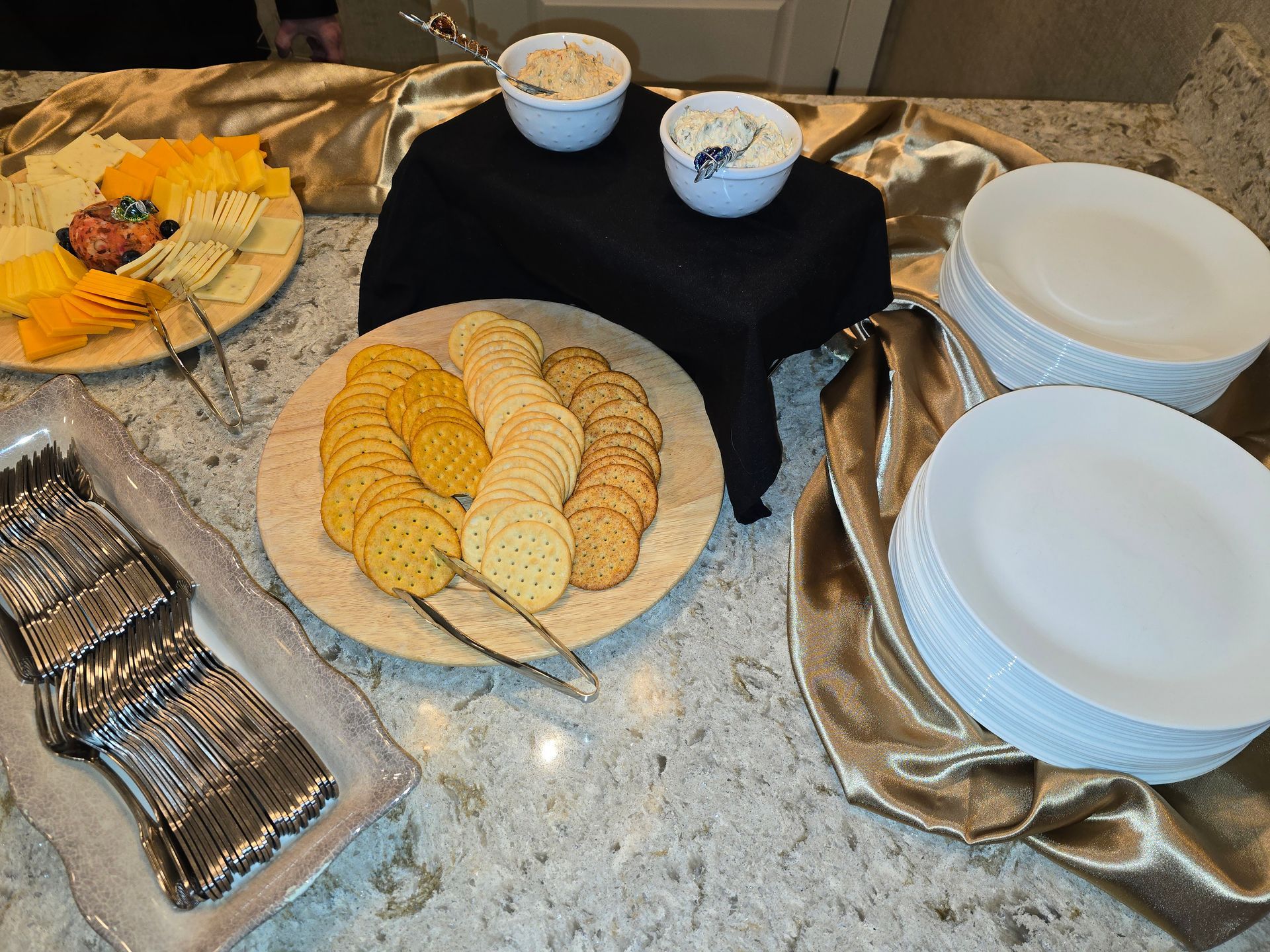 Table with assorted cookies and snacks in bowls, plates, and trays on a patterned tablecloth