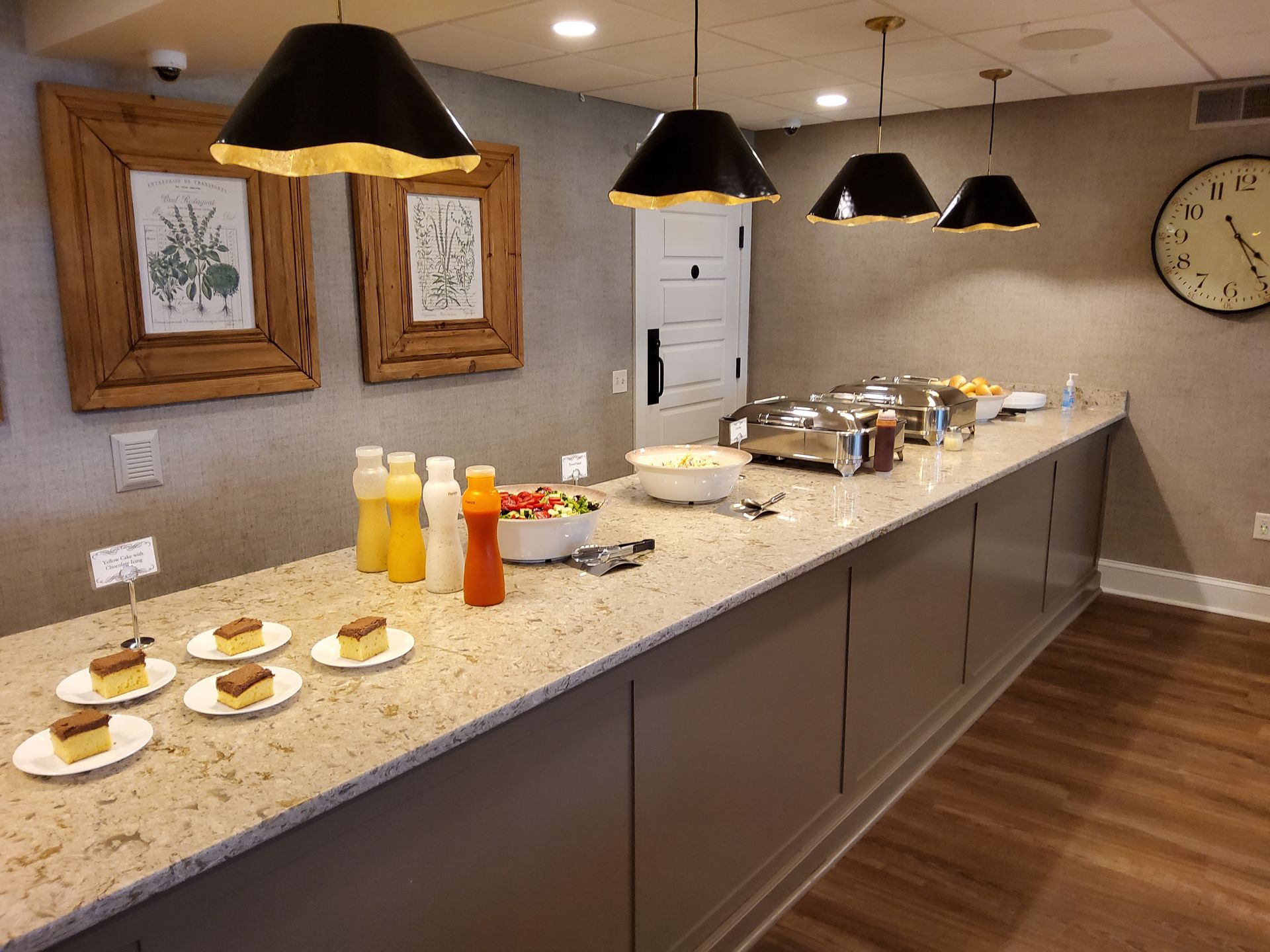 Buffet counter with pastries, drinks, and coffee in a warmly lit dining room