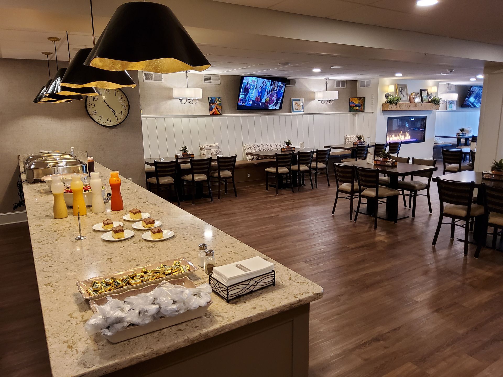 Hotel breakfast buffet with coffee station, pastries, and dining tables in a spacious dining room
