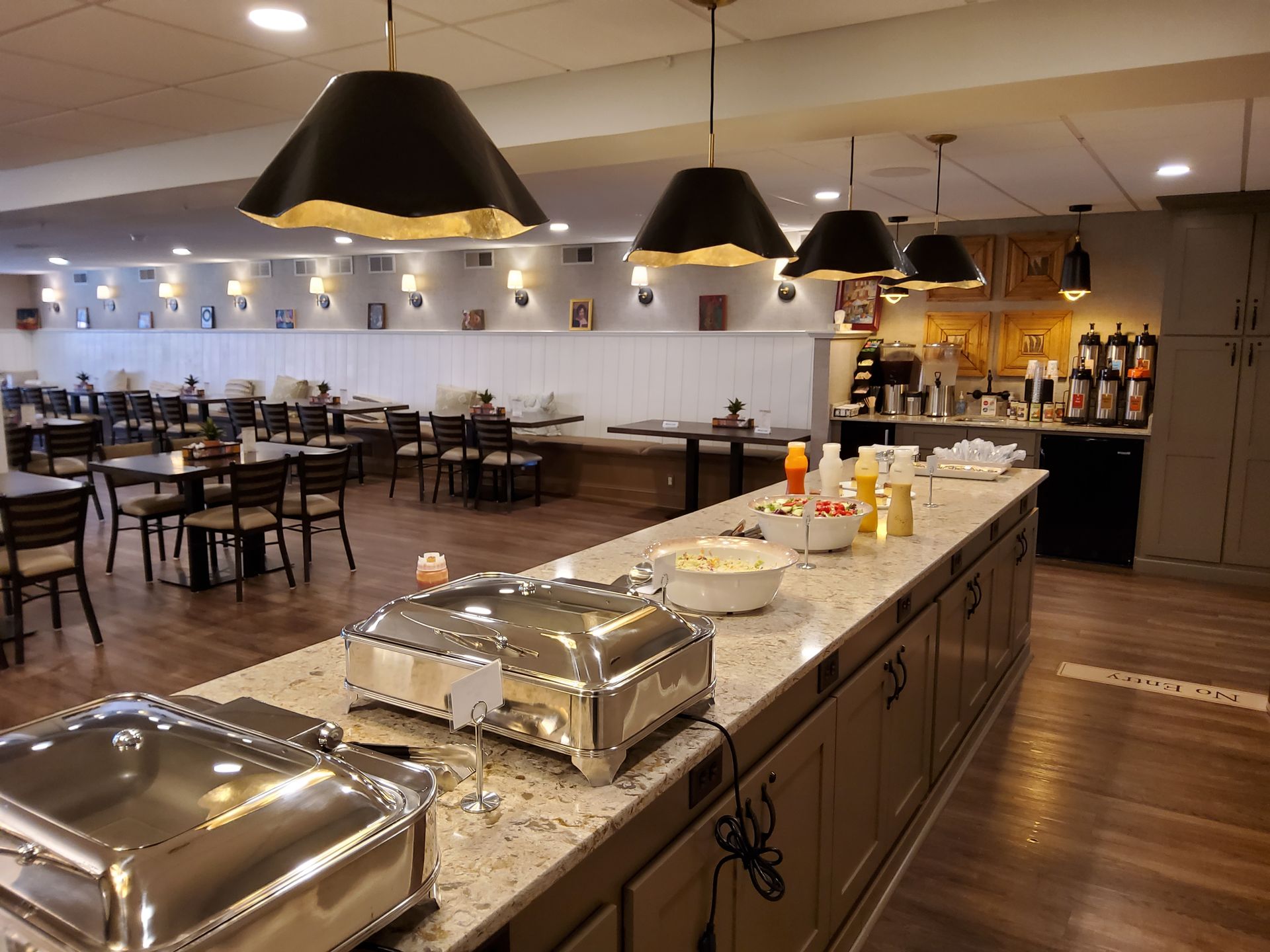 Buffet restaurant with granite counter, chafing dishes, tables, and warm pendant lights