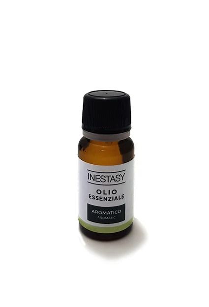 Una piccola bottiglia di olio essenziale è appoggiata su una superficie bianca.