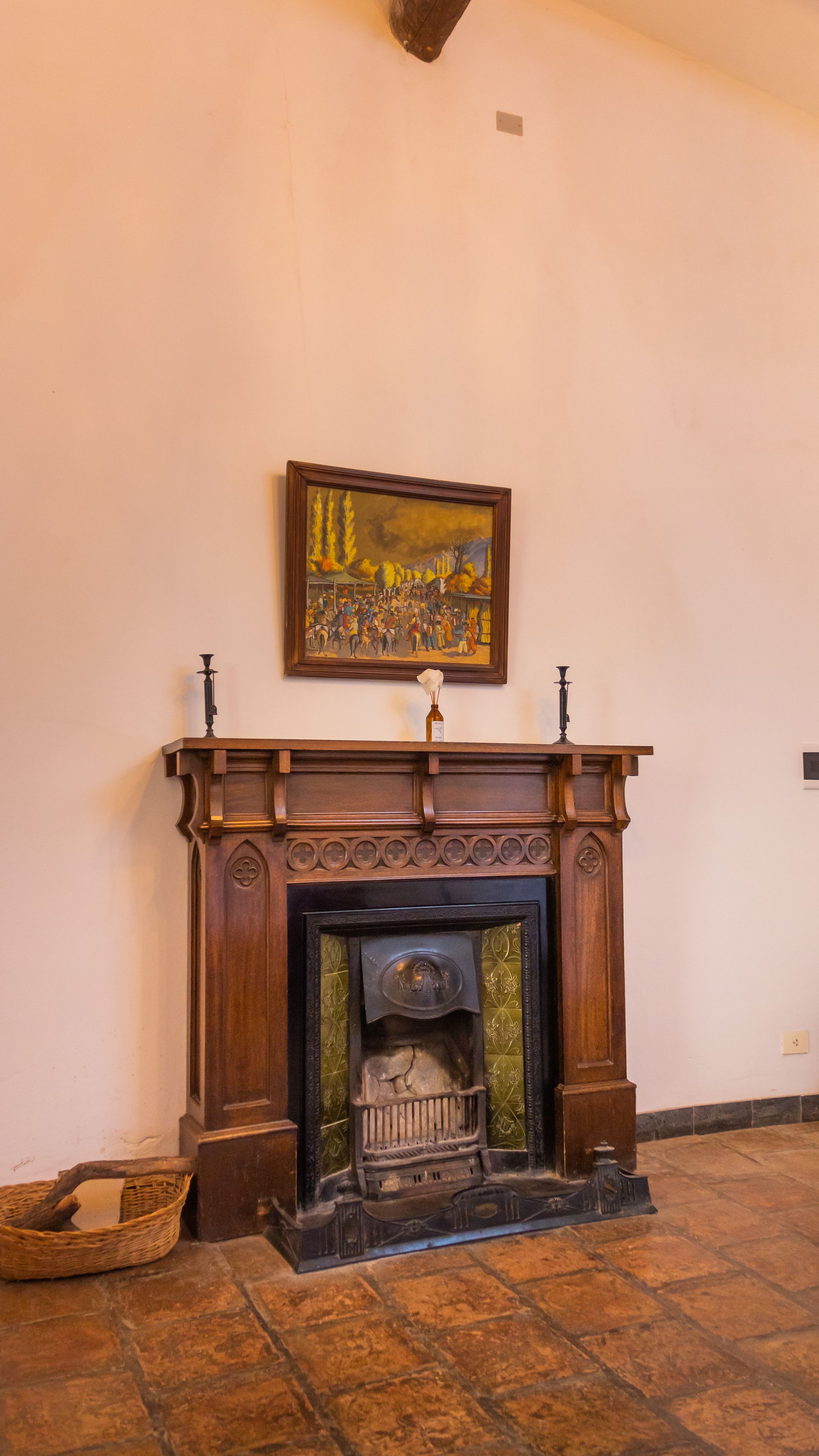 A fireplace in a living room with a painting on the wall above it.