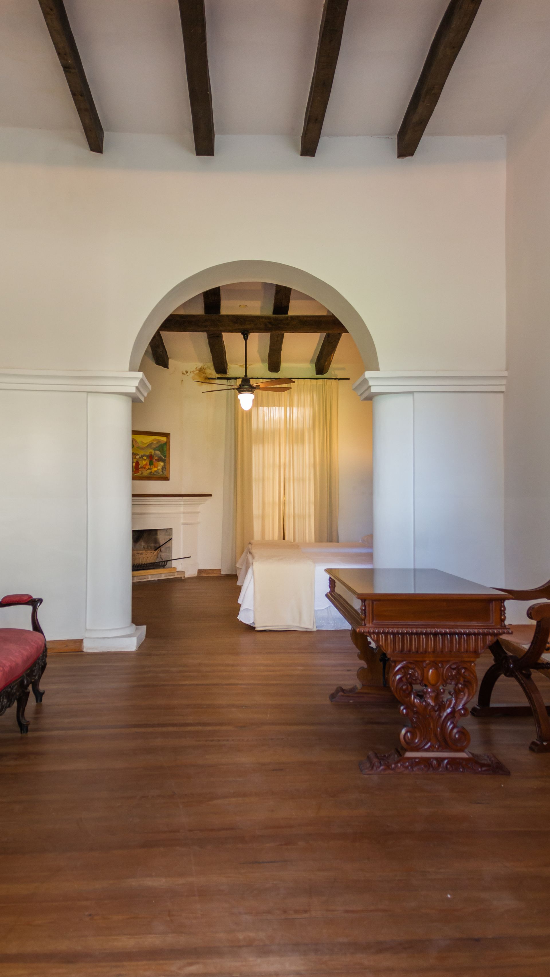 A living room with a wooden table and chairs and a bed.