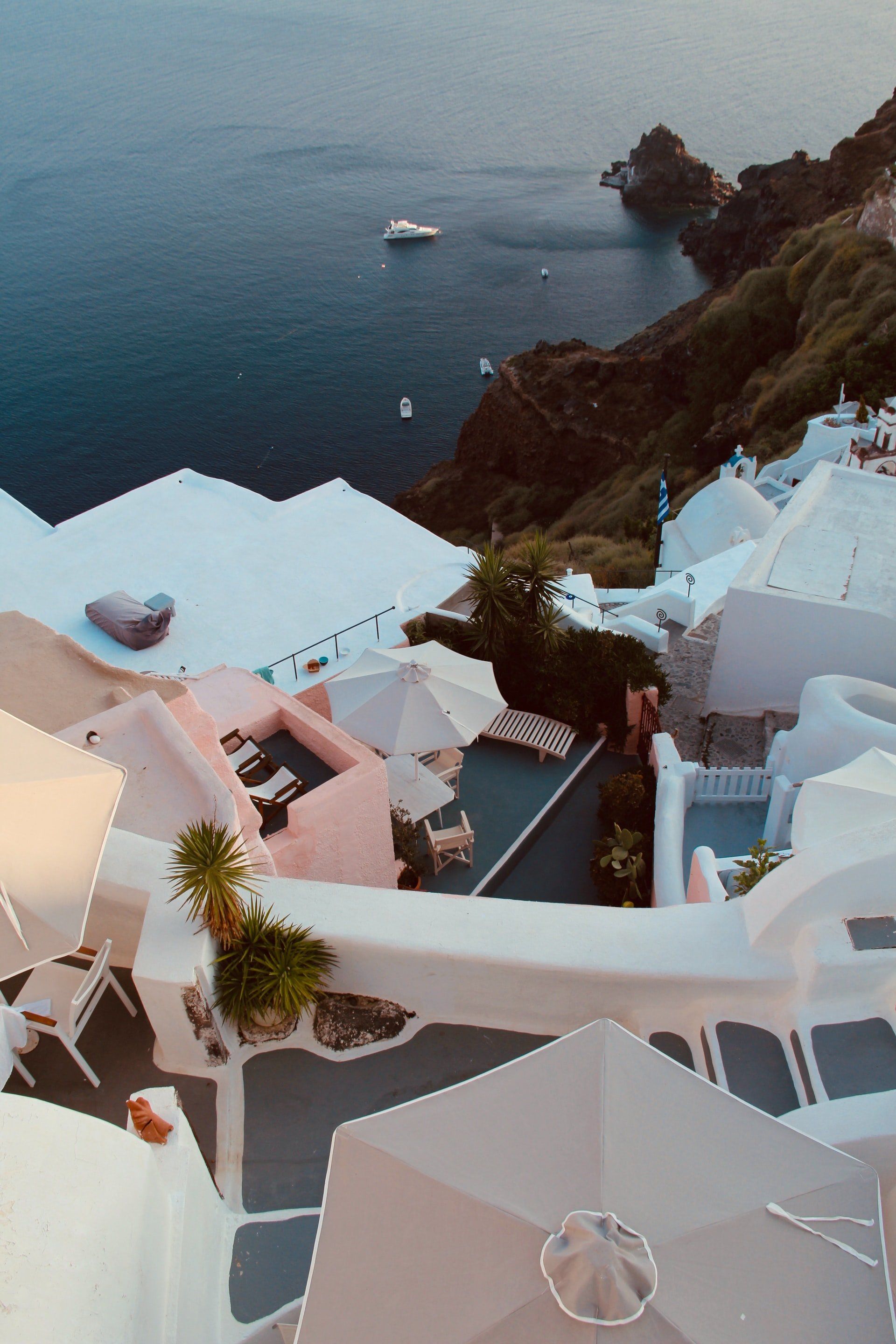 A view of the ocean from a balcony with umbrellas