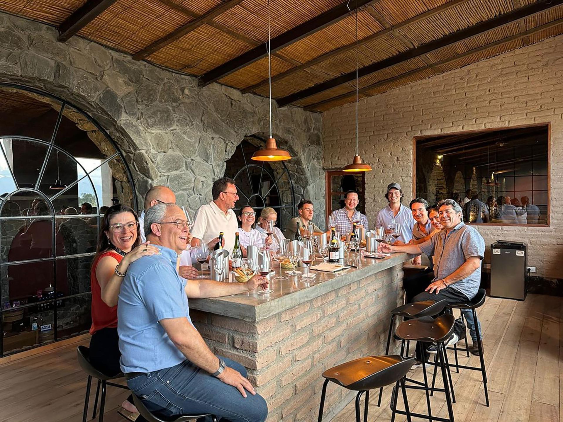 A group of people are sitting at a long table in a restaurant.