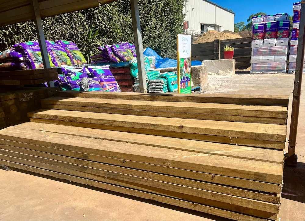 A Stack of Wooden Boards Sitting on Top of Each Other in a Yard — Highfields Landscape Supplies In Dalby, QLD