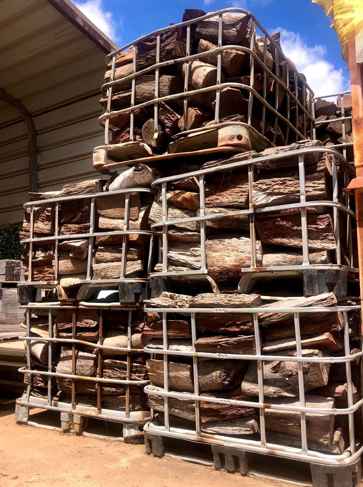 A Metal Crate Filled With Wood is Sitting on the Ground — Highfields Landscape Supplies In Meringandan, QLD