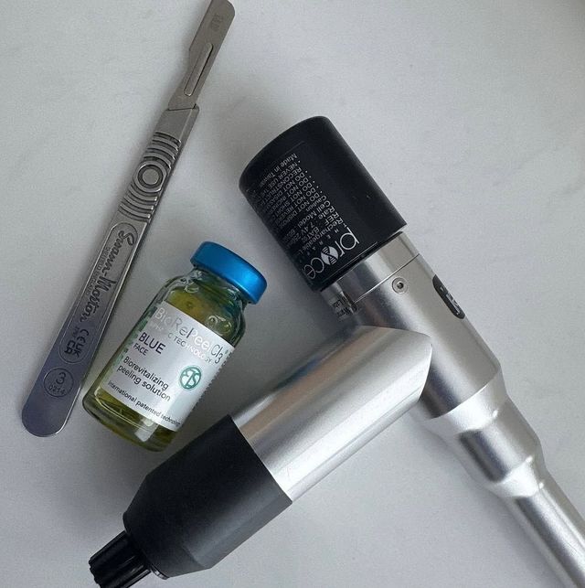 Three medical instruments and a small vial on a light surface