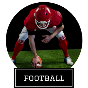 Football player in red gear crouches over a ball on green turf