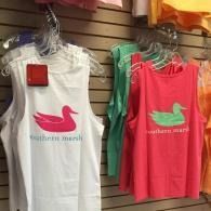 Tank tops with a swan logo hanging on store display hooks, in white, green, and pink.
