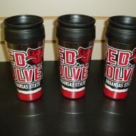 Three Red Wolves travel mugs with black lids on a dark table